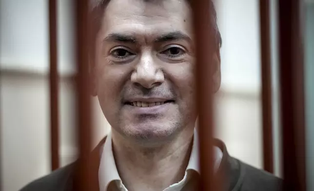 Grigory Melkonyants, co-chair of Russia's leading independent election monitoring group Golos who faces up to six years in prison, looks at the media standing in a cage in a courtroom prior to a hearing in Basmanny district court in Moscow, Russia, Wednesday, Oct. 9, 2024. (AP Photo)