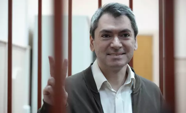 Grigory Melkonyants, co-chair of Russia's leading independent election monitoring group Golos who faces up to six years in prison, stands in a cage in a courtroom prior to a hearing in Basmanny district court in Moscow, Russia, Wednesday, Oct. 9, 2024. (AP Photo)