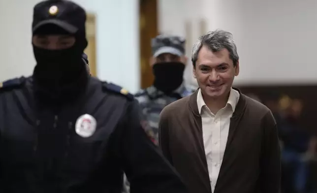 Grigory Melkonyants, co-chair of Russia's leading independent election monitoring group Golos who faces up to six years in prison, is escorted to a courtroom prior to a hearing in Basmanny district court in Moscow, Russia, Wednesday, Oct. 9, 2024. (AP Photo)