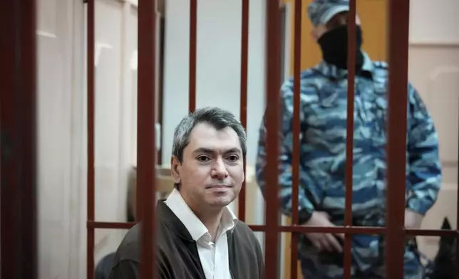 Grigory Melkonyants, co-chair of Russia's leading independent election monitoring group Golos, who faces up to six years in prison, stands in a cage in a courtroom prior to a hearing in Basmanny district court in Moscow, Russia, Wednesday, Oct. 9, 2024. (AP Photo)