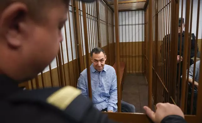 French citizen Laurent Vinatier sits in a cage prior to a court session at the Zamoskvoretsky District Court in Moscow, Russia, on Monday, Oct. 14, 2024. (AP Photo/Pavel Bednyakov)