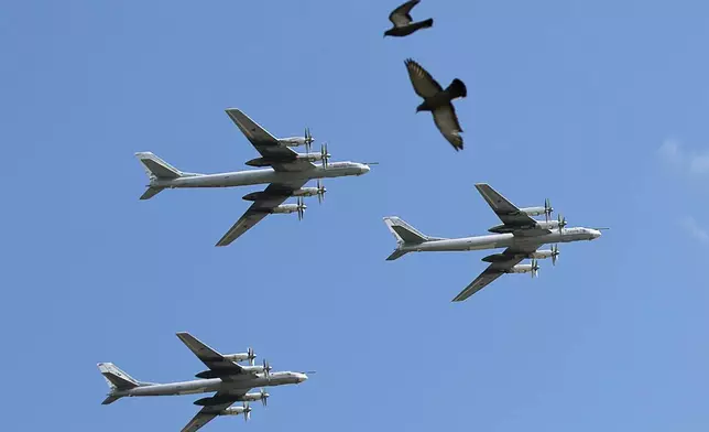 FILE - A trio of Tu-95 nuclear-capable strategic bombers of the Russian air force fly over Pushkin Square in Moscow, Russia, on May 3, 2014 during a rehearsal for the Victory Day military parade which will take place at Moscow's Red Square on May 9 to celebrate 69 years of the victory in WWII. (AP Photo/Pavel Golovkin, File)