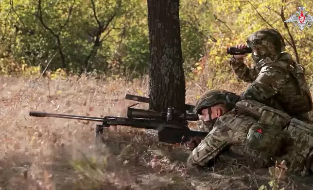 In this image made from video released by the Russian Defense Ministry on Friday, Oct. 11, 2024, a Russian sniper, in an undisclosed location, fires towards Ukrainian forces. (Russian Defense Ministry Press Service via AP)