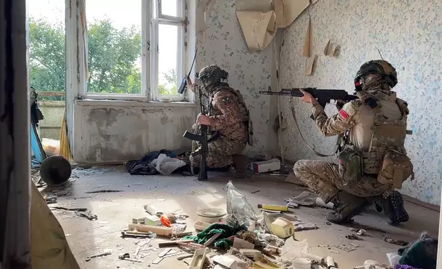 In this photo released by Russian Defense Ministry Press Service on Thursday, Oct. 17, 2024, Russian soldiers signalmen are seen in an apartment building on an undisclosed location in Ukraine. (Russian Defense Ministry Press Service via AP)