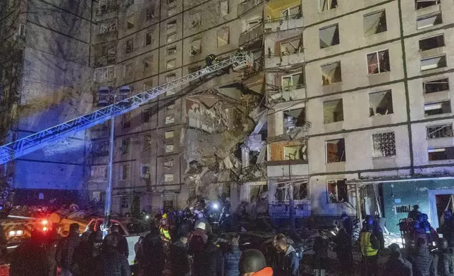 Rescuers help people after a multi-storey apartment building was hit by Russian attack in Kharkiv, Ukraine, late Wednesday, Oct. 30, 2024. (AP Photo/Andrii Marienko)