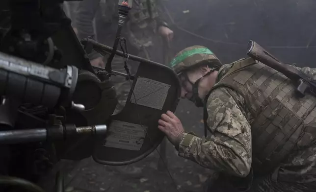 Ukrainian serviceman of Khartia brigade checks the D-30 Howitzer after firing towards Russian positions in Kharkiv region, Ukraine, Wednesday, Oct. 16, 2024. (AP Photo/Alex Babenko)