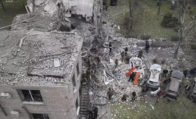 In this photo provided by the Ukrainian Emergency Service, emergency workers clear the rubble after an overnight Russian attack with guided bombs in Zaporizhzhia, Ukraine, Monday, Oct. 21, 2024. (Ukrainian Emergency Service via AP)