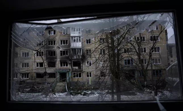 FILE - A residential building which was destroyed by Russian forces is seen through the broken window, in the frontline city of Vuhledar, Ukraine, Feb. 25, 2023. (AP Photo/Evgeniy Maloletka, File)