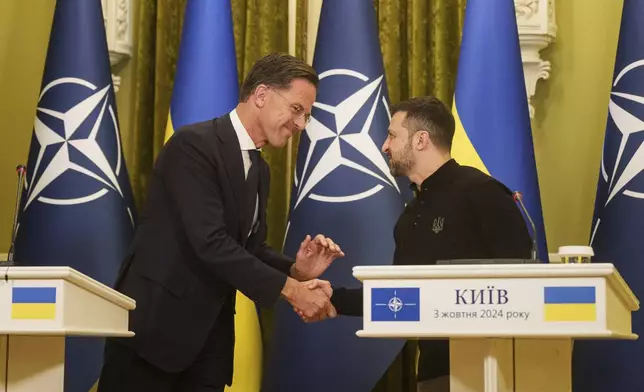 NATO Secretary General Mark Rutte, left, and Ukrainian President Volodymyr Zelenskyy, right, shake hands during press conference in Kyiv, Ukraine, Thursday, Oct. 3, 2024. (AP Photo/Evgeniy Maloletka)