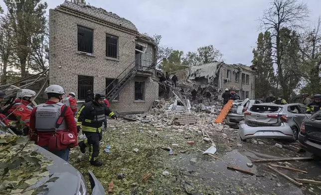 In this photo provided by the Ukrainian Emergency Service, emergency workers clear the rubble after Russia attacked the city with guided bombs overnight in Zaporizhzhia, Ukraine, Monday, Oct. 21, 2024. (Ukrainian Emergency Service via AP)