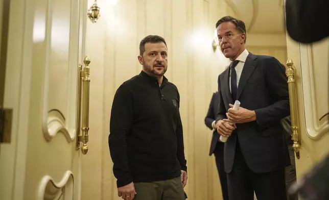 NATO Secretary General Mark Rutte, left, and Ukrainian President Volodymyr Zelenskyy speak in a corridor ahead of a press conference in Kyiv, Ukraine, Thursday Oct. 3, 2024. (AP Photo/Evgeniy Maloletka)