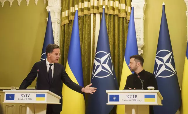 NATO Secretary General Mark Rutteleft, and Ukrainian President Volodymyr Zelenskyy, right, speak to journalists during press conference in Kyiv, Ukraine, Thursday, Oct. 3, 2024. (AP Photo/Evgeniy Maloletka)