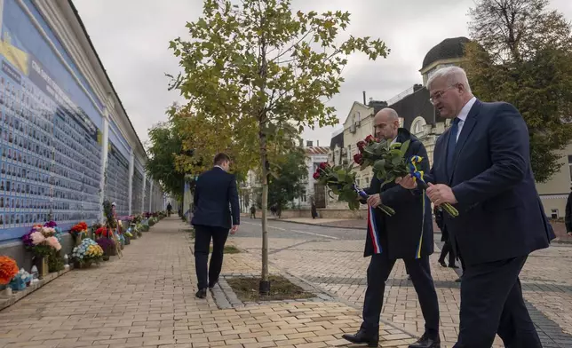 French Foreign Minister Jean-Noel Barrot and Ukrainian Minister of Foreign Affairs Andrii Sybiha lay flowers at the memorial for Ukrainian killed soldiers inin central Kyiv, Ukraine, Saturday, Oct. 19, 2024. (AP Photo/Alex Babenko)