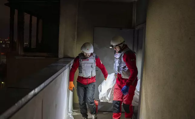 A medical emergency team carry the body of a teenager who died after a Russian attack in Kyiv, Ukraine, early Saturday, Oct. 26, 2024. (AP Photo/Alex Babenko)