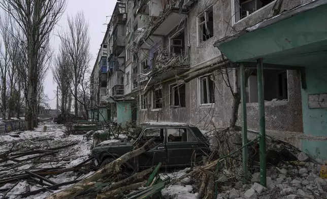 FILE - A destroyed car is seen in front of a residential building which was heavily bombed by Russian forces, in the frontline city of Vuhledar, Ukraine, Feb. 25, 2023. (AP Photo/Evgeniy Maloletka, File)