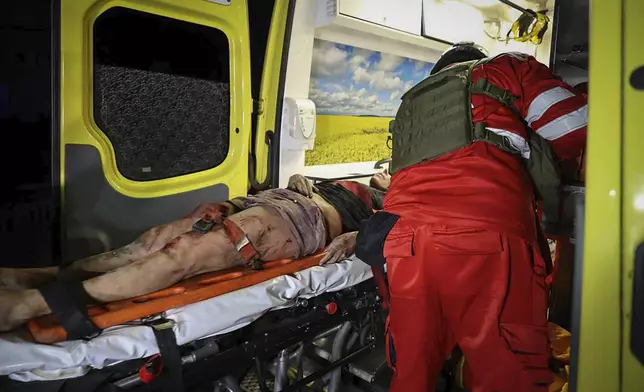 In this photo provided by Kharkiv City Administration, an ambulance evacuates an injured man after a multi-storey apartment building was hit by Russian attack in Kharkiv, Ukraine, late Wednesday, Oct. 30, 2024. (Kharkiv City Administration via AP)