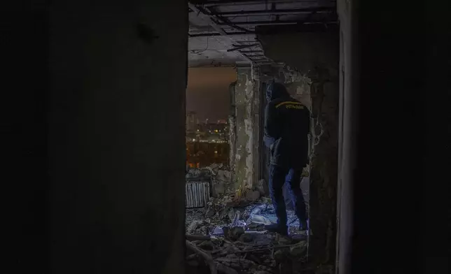 A firefighter observes the site of the Russian drone attack that killed a teenager in Kyiv, Ukraine, early Saturday, Oct. 26, 2024. (AP Photo/Alex Babenko)