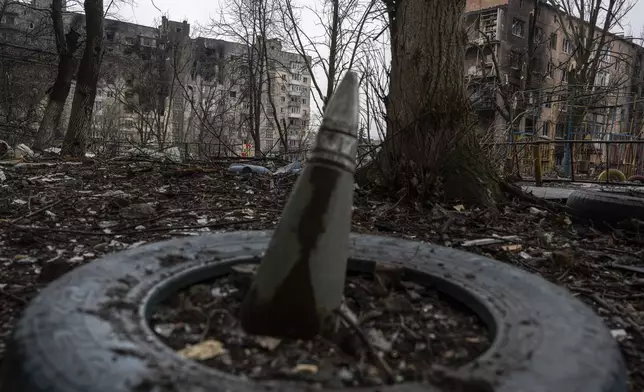 FILE - A part of a rocket sticks from a ground in front of a residential building which was heavily bombed by Russian forces in the frontline city of Vuhledar, Ukraine, Feb. 25, 2023. (AP Photo/Evgeniy Maloletka)