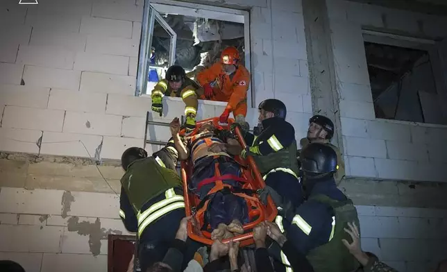 In this photo provided by the Ukrainian Emergency Service, Emergency workers carry a wounded resident after Russian missile attack in Odesa, Ukraine, late Thursday, Oct. 10, 2024. Four Russian missile and drone attacks on the Odesa region this week have killed 14 people and wounded around 20, according to local officials. (Ukrainian Emergency Service via AP)