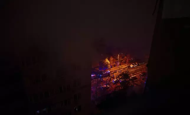 Emergency service vehicles are seen through the smoke from a fire caused by the attack of Russian drones that killed a teenager in Kyiv, Ukraine, Friday, Oct. 25, 2024. (AP Photo/Alex Babenko)