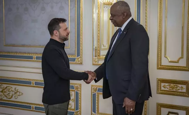 In this photo provided by the Press Service Of The President Of Ukraine on Oct. 21, 2024, U.S. Secretary of Defense Lloyd Austin, right, and Ukraine's President Volodymyr Zelenskyy shake hands during their meeting in Kyiv, Ukraine. (Press Service Of The President Of Ukraine via AP)