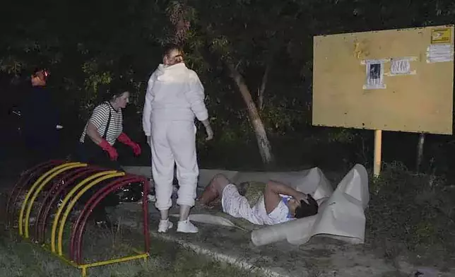 In this photo provided by the Ukrainian Emergency Service, Emergency workers provide first aid to a wounded resident after a Russian missile attack that killed four, injured ten in Odesa, Ukraine, late Thursday, Oct. 10, 2024. (Ukrainian Emergency Service via AP)