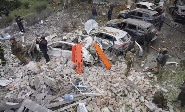 In this photo provided by the Ukrainian Emergency Service, emergency workers clear the rubble after Russia attacked the city with guided bombs overnight in Zaporizhzhia, Ukraine, Monday, Oct. 21, 2024. (Ukrainian Emergency Service via AP)