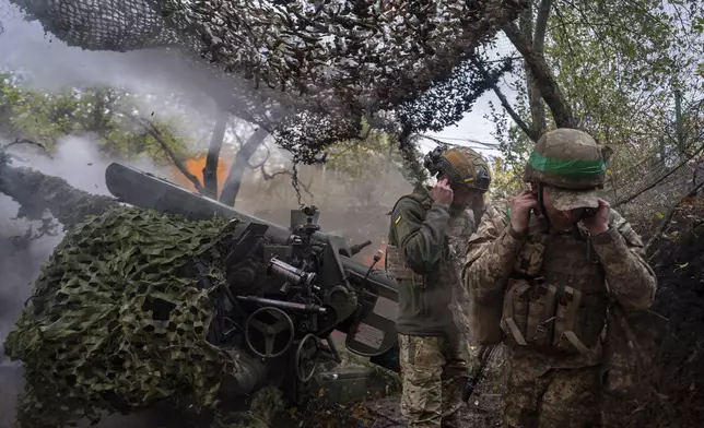 Ukrainian servicemen of Khartia brigade fire D-30 Howitzer towards Russian positions in Kharkiv region, Ukraine, Wednesday, Oct. 16, 2024. (AP Photo/Alex Babenko)