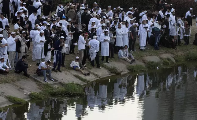 Orthodox Jews pray near the lake at the tomb of Rabbi Nachman, the great grandson of the founder of Hasidic movement, in the town of Uman, 200 kilometers (125 miles) south of Ukraine's capital Kyiv, Ukraine, Thursday, Oct. 3, 2024. (AP Photo/Efrem Lukatsky)