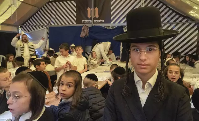 Orthodox Jewish children pray at the gravestone of Rabbi Nachman, the great grandson of the founder of Hasidic movement, to mark the Jewish new year in the town of Uman, 200 kilometers (125 miles) south of Ukraine's capital Kyiv, Ukraine, Thursday, Oct. 3, 2024. (AP Photo/Efrem Lukatsky)