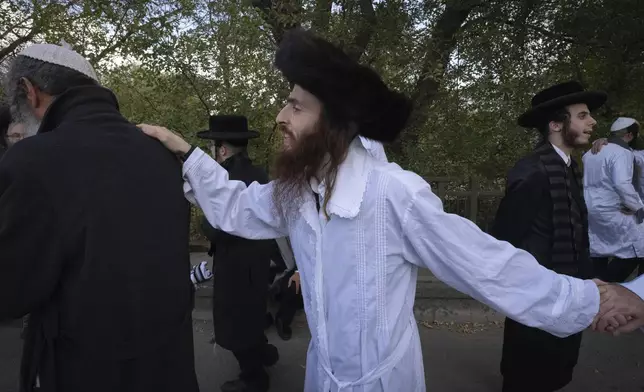 Orthodox Jews dance at the tomb of Rabbi Nachman, the great grandson of the founder of Hasidic movement, in the town of Uman, 200 kilometers (125 miles) south of Ukraine's capital Kyiv, Ukraine, Thursday, Oct. 3, 2024. (AP Photo/Efrem Lukatsky)