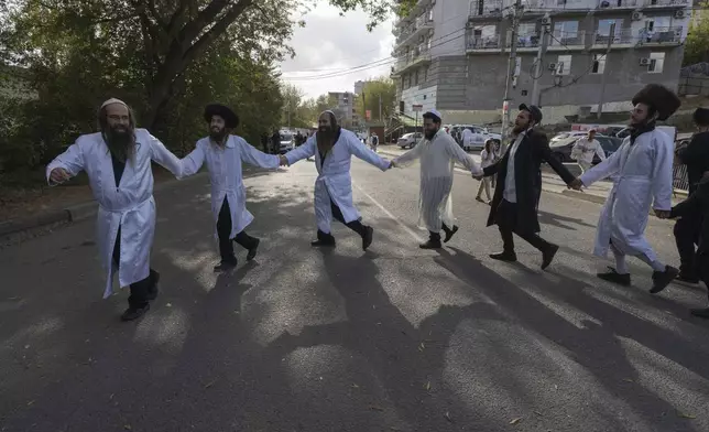 Orthodox Jews dance at the tomb of Rabbi Nachman, the great grandson of the founder of Hasidic movement, in the town of Uman, 200 kilometers (125 miles) south of Ukraine's capital Kyiv, Ukraine, Thursday, Oct. 3, 2024. (AP Photo/Efrem Lukatsky)