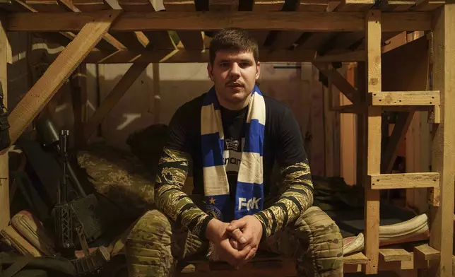 Ukrainian serviceman known by the call sign "Ball" of the 3rd assault brigade sits on a bed not far from the frontline in Kharkiv region, Ukraine, Sunday Sept. 22, 2024. (AP Photo/Evgeniy Maloletka)