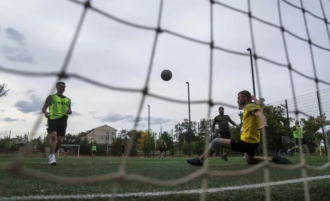 Ukrainian servicemen of 3rd assault brigade play soccer in Izium, Ukraine, Thursday Sept. 26, 2024. (AP Photo/Evgeniy Maloletka)