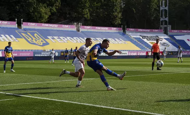 Mykola Mykhailenko of Dynamo Kyiv, clears the ball as Ihor Kiriukhantsev of Zorya Luhansk closes in during a soccer match of Ukrainian Premier League in Kyiv, Ukraine, Saturday Sept. 14, 2024. (AP Photo/Evgeniy Maloletka)