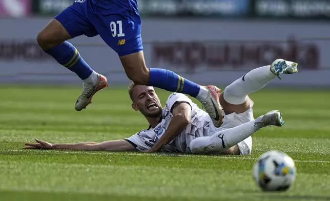 Mykola Mykhailenko of Dynamo Kyiv and Petar Michin of Zorya Luhansk, bottom, in action during a soccer match of Ukrainian Premier League in Kyiv, Ukraine, Saturday Sept. 14, 2024. (AP Photo/Evgeniy Maloletka)