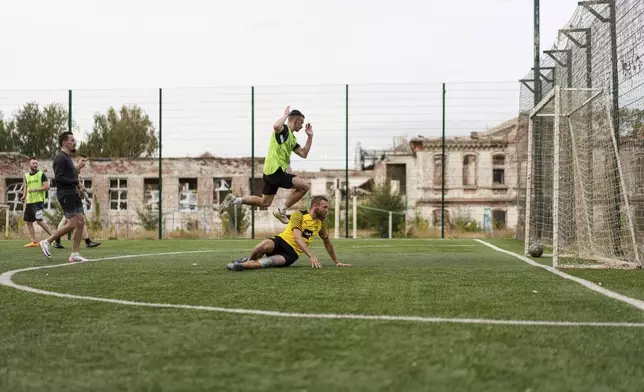 Ukrainian servicemen of the 3rd assault brigade play soccer in Izium, Ukraine, Thursday Sept. 26, 2024. (AP Photo/Evgeniy Maloletka)