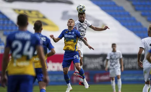 Vitalii Buyalskiy of Dynamo Kyiv and Oleksiy Khakhliyov of Zorya Luhansk, top, compete for the ball as they play a soccer match of Ukrainian Premier League in Kyiv, Ukraine, Saturday Sept. 14, 2024. (AP Photo/Evgeniy Maloletka)