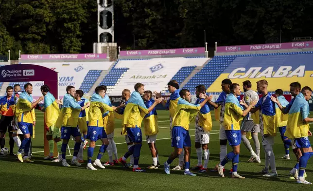 Soccer players of Dynamo Kyiv and Zorya Luhansk great each other before game of Ukrainian Premier League in Kyiv, Ukraine, Saturday Sept. 14, 2024. (AP Photo/Evgeniy Maloletka)