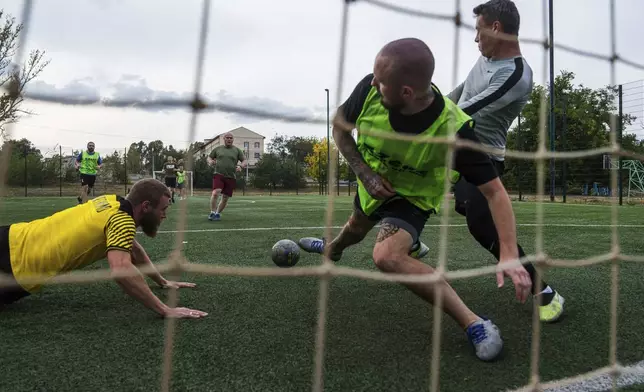 Ukrainian servicemen of 3rd assault brigade play soccer in Izium, Ukraine, Thursday Sept. 26, 2024. (AP Photo/Evgeniy Maloletka)