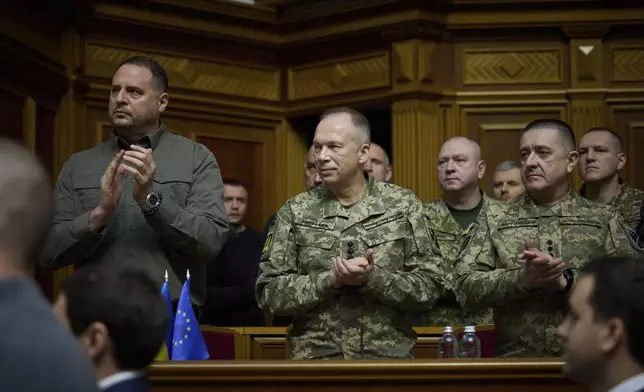 In this photo provided by the Press Service Of The President Of Ukraine on Oct. 16, 2024, Head of Ukrainian Presidential Office Andriy Yermak,left, and Commander-in-Chief of the Armed Forces of Ukraine General Oleksandr Syrskyi,center, listen a speech of Ukraine's President Volodymyr Zelenskyy at Verkhovna Rada in Kyiv, Ukraine. (Press Service Of The President Of Ukraine via AP)