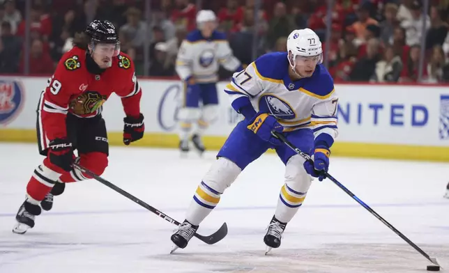 Buffalo Sabres right wing JJ Peterka, right, controls the puck against Chicago Blackhawks left wing Tyler Bertuzzi during the first period of an NHL hockey game, Saturday, Oct. 19, 2024, in Chicago. (AP Photo/Melissa Tamez)