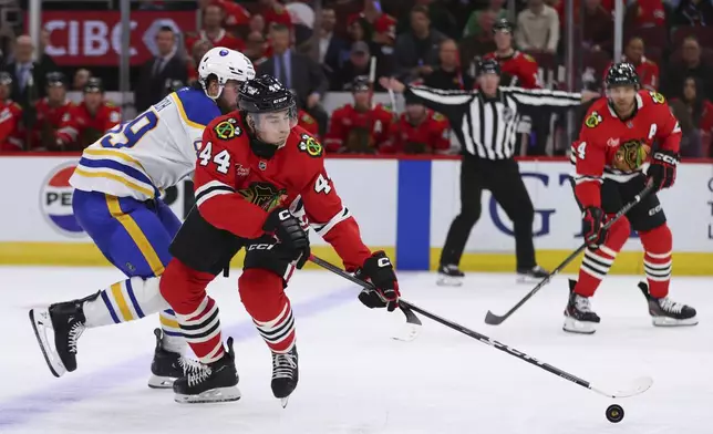 Chicago Blackhawks defenseman Wyatt Kaiser controls the puck against Buffalo Sabres right wing Alex Tuch during the third period of an NHL hockey game, Saturday, Oct. 19, 2024, in Chicago. (AP Photo/Melissa Tamez)