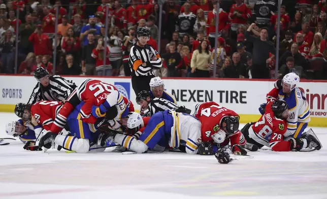 Referees break up multiple fights between the Buffalo Sabres and the Chicago Blackhawks during the third period of an NHL hockey game, Saturday, Oct. 19, 2024, in Chicago. (AP Photo/Melissa Tamez)