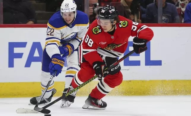 Buffalo Sabres right wing Jack Quinn battles for the puck against Chicago Blackhawks center Connor Bedard during the second period of an NHL hockey game, Saturday, Oct. 19, 2024, in Chicago. (AP Photo/Melissa Tamez)