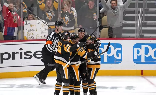 Pittsburgh Penguins' Evgeni Malkin (71) celebrates his 500th NHL goal with teammates during the third period of an NHL hockey game against the Buffalo Sabres in Pittsburgh, Wednesday, Oct. 16, 2024. (AP Photo/Gene Puskar)