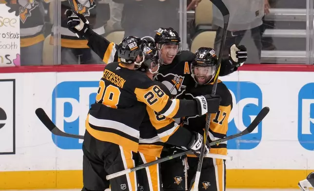 Pittsburgh Penguins' Evgeni Malkin celebrates his 500th NHL goal with teammates during the third period of an NHL hockey game against the Buffalo Sabres in Pittsburgh, Wednesday, Oct. 16, 2024. (AP Photo/Gene Puskar)