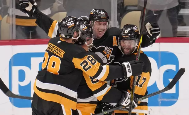 Pittsburgh Penguins' Evgeni Malkin celebrates his 500th NHL goal with teammates during the third period of an NHL hockey game against the Buffalo Sabres in Pittsburgh, Wednesday, Oct. 16, 2024. (AP Photo/Gene Puskar)