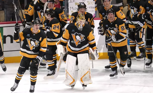 Pittsburgh Penguins' Evgeni Malkin celebrates his 500th NHL goal with teammates during the third period of an NHL hockey game against the Buffalo Sabres in Pittsburgh, Wednesday, Oct. 16, 2024. (AP Photo/Gene Puskar)