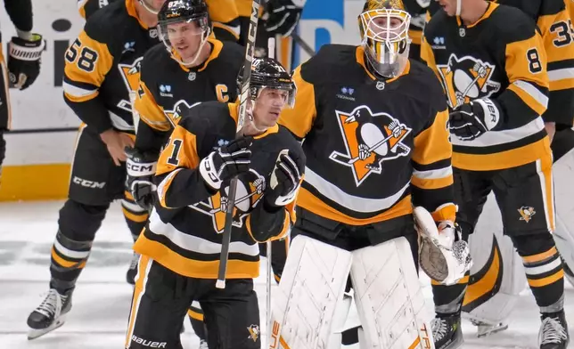 Pittsburgh Penguins' Evgeni Malkin celebrates his 500th NHL goal with teammates during the third period of an NHL hockey game against the Buffalo Sabres in Pittsburgh, Wednesday, Oct. 16, 2024. (AP Photo/Gene Puskar)